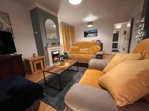a living room with a couch and a fireplace at Lovely Stylish 3 Bed House with Free Parking in Norwich
