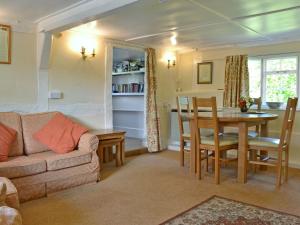 a living room with a couch and a table at October Cottage in Collingbourne Kingston