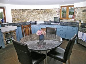 a kitchen with a table with chairs and a counter top at Thornsdale Oast House in Stone