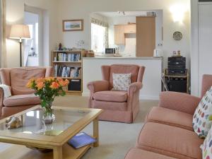 a living room with two chairs and a table at Craigneish Bungalow in Trearddur