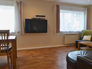 a living room with a flat screen tv on the wall at Moors Rest in Sculthorpe