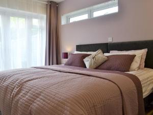 a bedroom with a large bed with a large window at Moors Rest in Sculthorpe