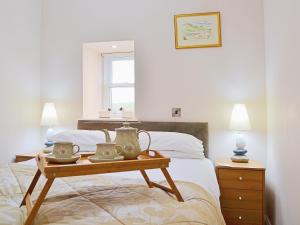 a bedroom with a bed and a table with tea pots on it at Castle Smiddy - 27900 in Ceres