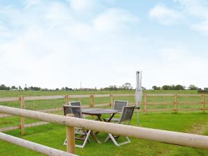 una mesa y sillas sentadas junto a una valla en The Old Carthouse, en Abbots Bromley