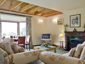 a living room with couches and a fireplace at Loch Alsh Cottage - Uvo in Balmacara