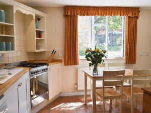 チッピング・カムデンにあるRose Cottage No2 - 28440の窓、テーブル付きのキッチンが備わります。