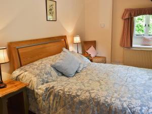 ein Schlafzimmer mit einem Bett mit einem Kissen darauf in der Unterkunft Rose Cottage No2 - 28440 in Chipping Campden