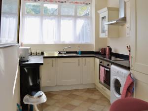 a kitchen with a sink and a washing machine at Porters Lodge in Glyn-Dyfrdwy