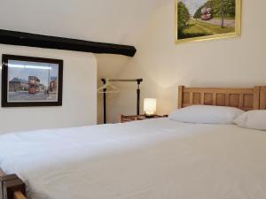 a bedroom with a large white bed and a window at Porters Lodge in Glyn-Dyfrdwy