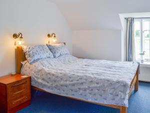 a bedroom with a bed and a dresser and a window at Dragon Fly Cottage in Brompton
