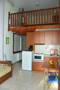 a kitchen with a white refrigerator and a staircase at Zouzoula House in Milina