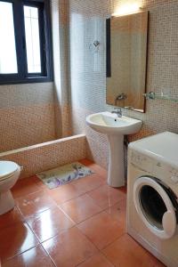 a bathroom with a washing machine and a sink at Βίλα Ηρώ in Riglia