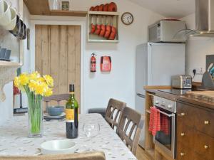 a kitchen with a table with a bottle of wine on it at Brynhoreb in Llanilar