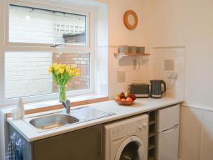 a kitchen with a sink and a washing machine at Broughs House in Broomhill