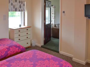 Saint KeverneにあるManacle Viewのベッドルーム1室(ベッド1台、ドレッサー、窓付)