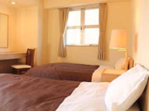 Postel nebo postele na pokoji v ubytování HOTEL LiVEMAX BUDGET Fuchu Annex