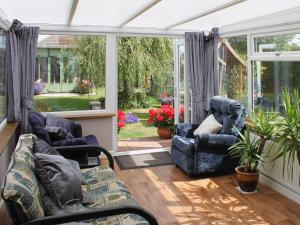 einen Wintergarten mit zwei Stühlen und einem Sofa in der Unterkunft Sandringham Heights in Paignton