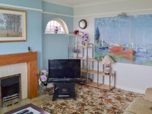 ein Wohnzimmer mit einem TV und einem Kamin in der Unterkunft Sandringham Heights in Paignton