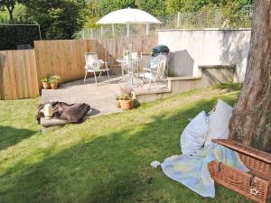 a backyard with a table and chairs and an umbrella at The Little House in Calstock