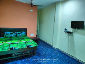 una camera da letto con un letto e una TV a schermo piatto di Shree Vighnaharta Cottage ad Alibaug