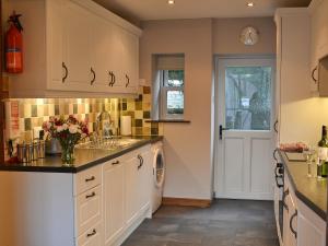 uma cozinha com um lavatório e uma máquina de lavar louça em The Granary em Carperby