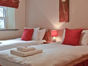 two beds in a room with red and white pillows at The Granary in Carperby