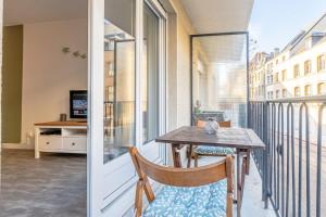 a balcony with a wooden table and chairs and a window at Casa Pestana in Metz