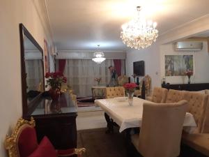 New Boutique Apartment Egypt في القاهرة: غرفة طعام مع طاولة وثريا