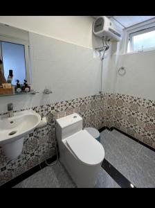 a bathroom with a toilet and a sink at Cuti House in Da Lat