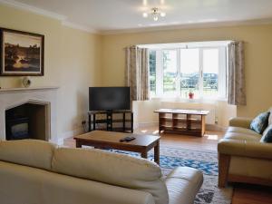 a living room with a couch and a tv at Clydesdale in North Somercotes