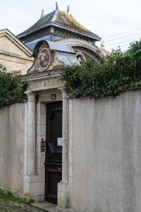 a building with a door with a roof at Le Cedre Bleu in Bourges