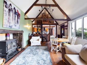 a living room with a fireplace and a table at The Old Coach House in Iddesleigh