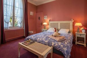 un dormitorio con una cama con un animal de peluche sentado en ella en Le Cedre Bleu en Bourges