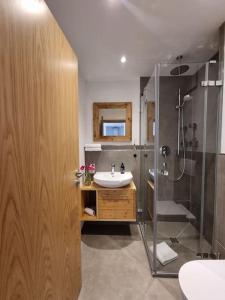 ein Bad mit einem Waschbecken und einer Dusche in der Unterkunft Phils Apartment in Rettenberg