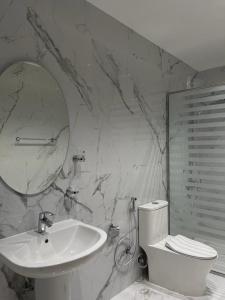 ein Badezimmer mit einem Waschbecken, einem WC und einem Spiegel in der Unterkunft Oxygen hatta in Hatta
