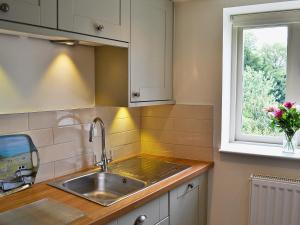 a kitchen with a sink and a window at Post Office Cottage in Highpeak Junction