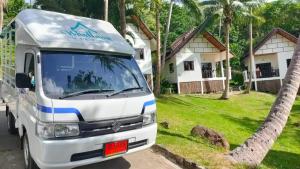ein weißer Van vor einem Haus geparkt in der Unterkunft Woodlawn Villas Resort in Ko Tao