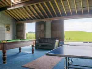 a living room with a pool table and a couch at Higher Paradise in Gisburn