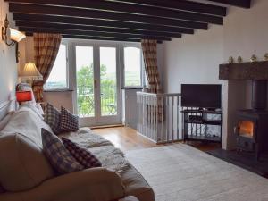 a living room with a couch and a fireplace at Y Teras in Rosebush