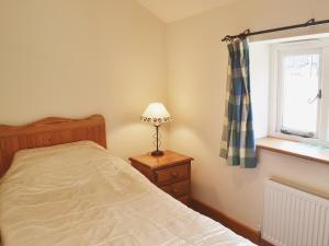 a bedroom with a bed and a window at Bluebell Cottage in Alburgh