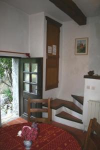 a living room with a staircase and a table with flowers at Le gite panda saint-maymes in Trigance