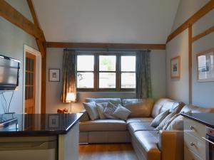 a living room with a couch and a window at Little Gable in Berrington