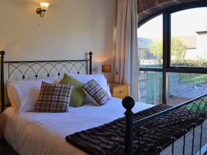 a bedroom with a bed and a large window at Corn Cottage in Fenham