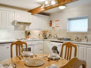 a kitchen with a table with wine glasses on it at Ash Cottage in Tarvin