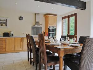 a dining room with a wooden table and chairs at Hendre Barn Mawr in Abergynolwyn