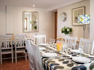 uma sala de jantar com uma mesa, cadeiras e um espelho em Whitehouse Farm em Hartington