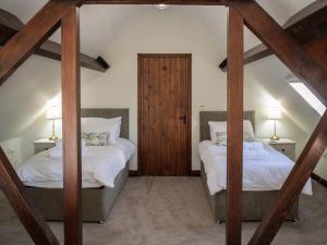 two twin beds in a room with two lamps at Whitehouse Farm in Hartington