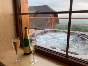 two glasses of champagne sitting on a table with a hot tub at Penzion U Pacošů in Malenovice