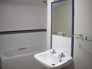a white bathroom with a sink and a bath tub at Whitehouse Farm in Hartington