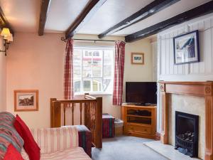 a living room with a fireplace and a television at Sharrowhead Cottage - E4044 in Robin Hood's Bay